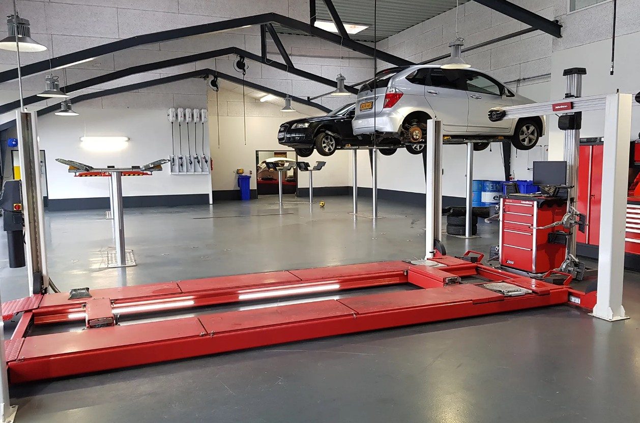 Ikast AutoServices værksted med biler på lift